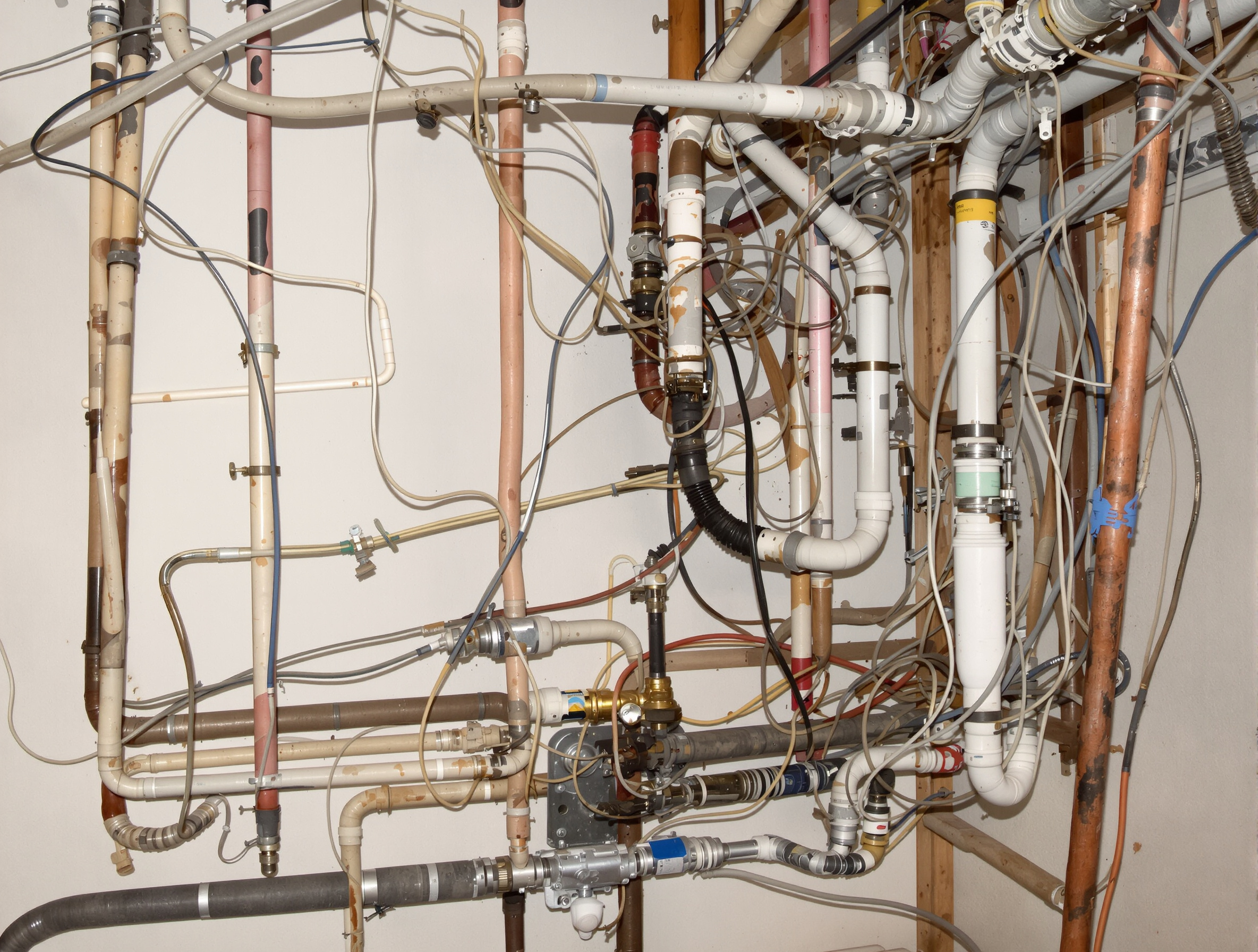 Installation de pompe à chaleur défectueuse avec tuyaux non isolés et connexions précaires.