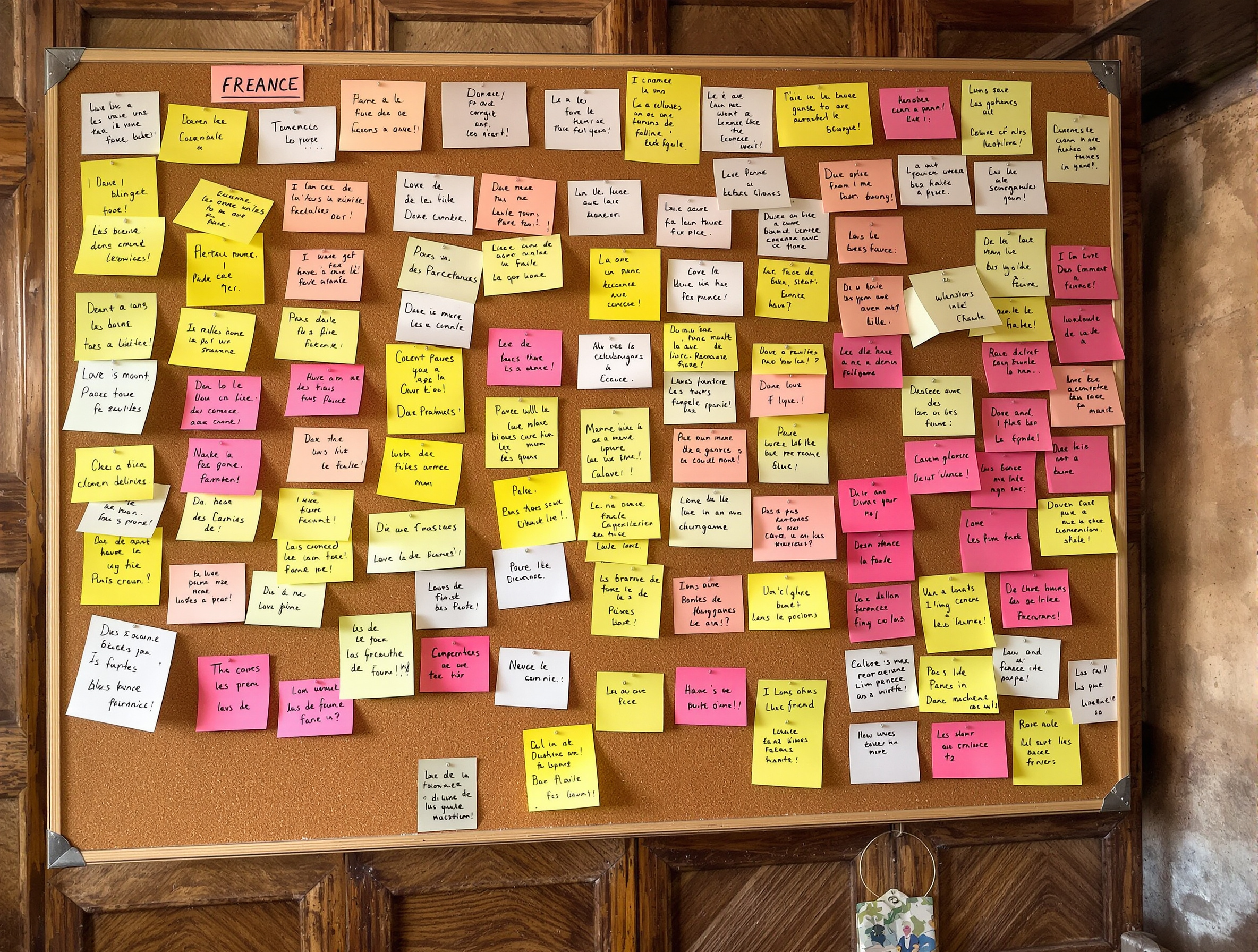 Panneau d'annonces en liège dans une mairie ariégeoise rempli de post-it manuscrits authentiques.